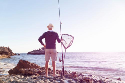 bigstock-Senior-man-fishing-at-sea-side-183125362